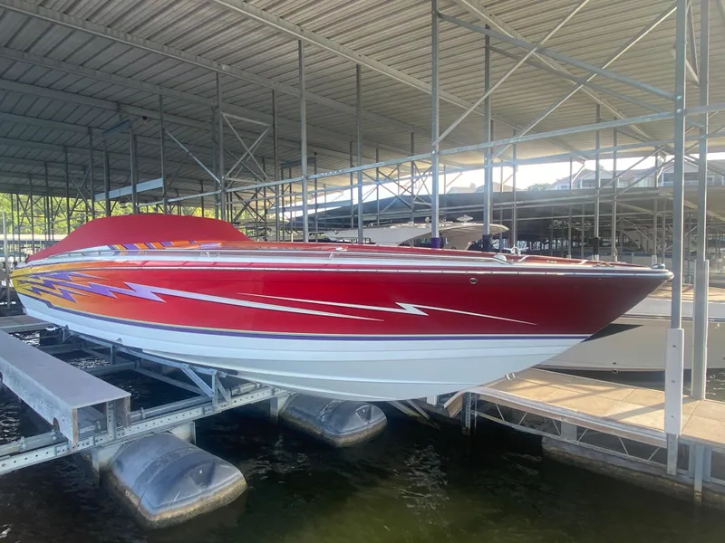 Slide: The Image of 2006 Formula 353 FASTech speedboat with vibrant red and orange design, docked in a marina. - 9
