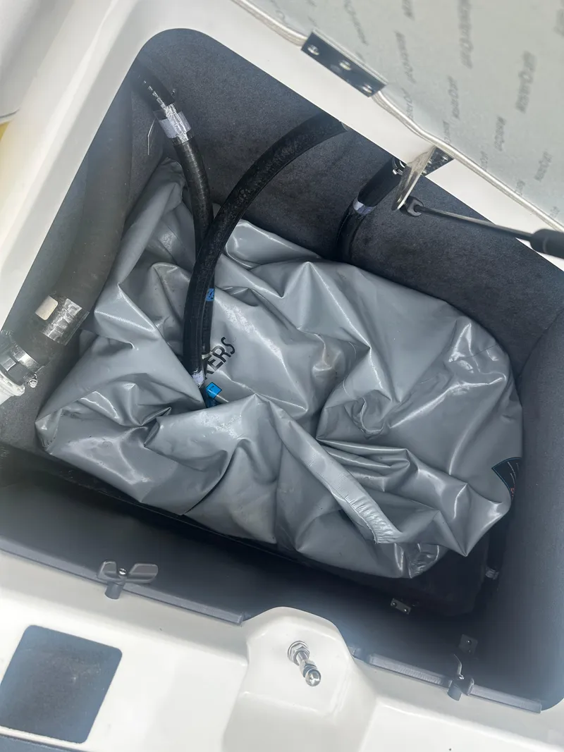 Slide: The Image of 2018 MasterCraft NXT22 storage compartment with gray bag and hoses inside. - 16