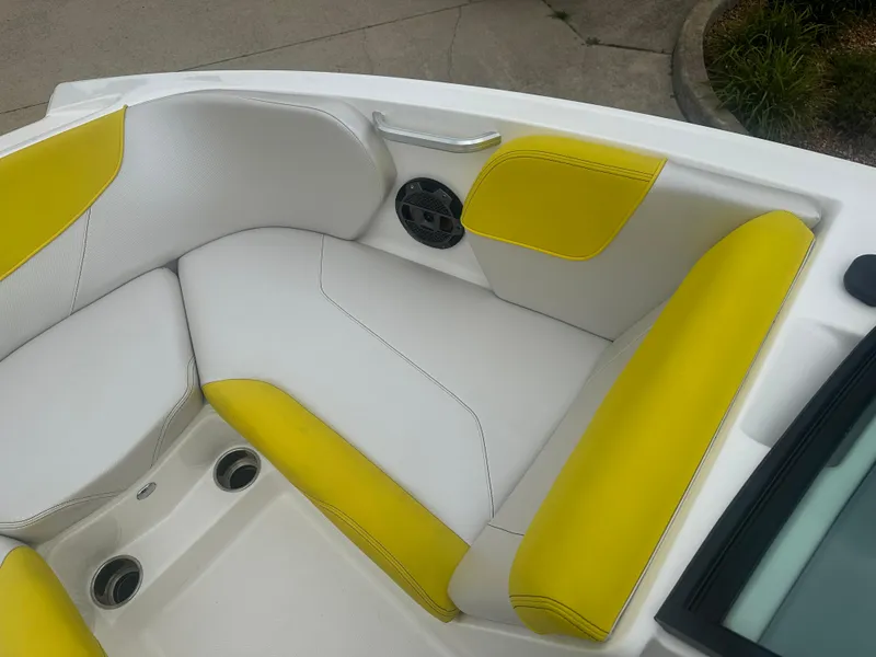 Slide: The Image of 2018 MasterCraft NXT22 boat interior with white and yellow seating, cup holders, and speaker. - 18