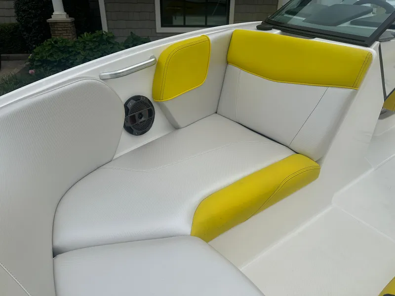Slide: The Image of 2018 MasterCraft NXT22 boat interior with white and yellow seating, featuring a built-in speaker. - 21