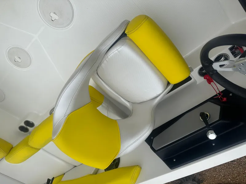 Slide: The Image of 2018 MasterCraft NXT22 boat interior with yellow and white seating, steering wheel, and controls. - 7