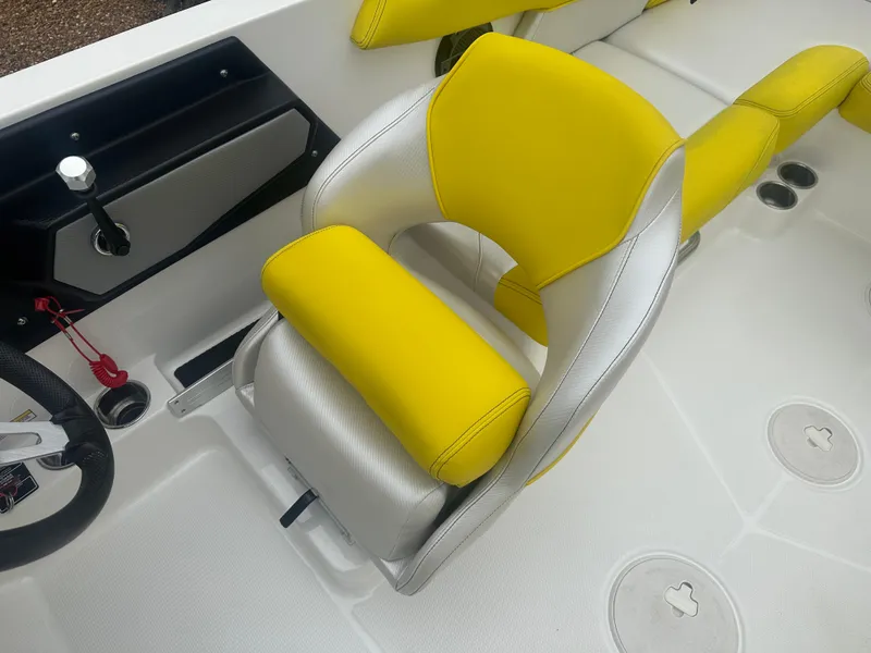 Slide: The Image of 2018 MasterCraft NXT22 boat interior with yellow and silver seating, steering wheel, and controls. - 8