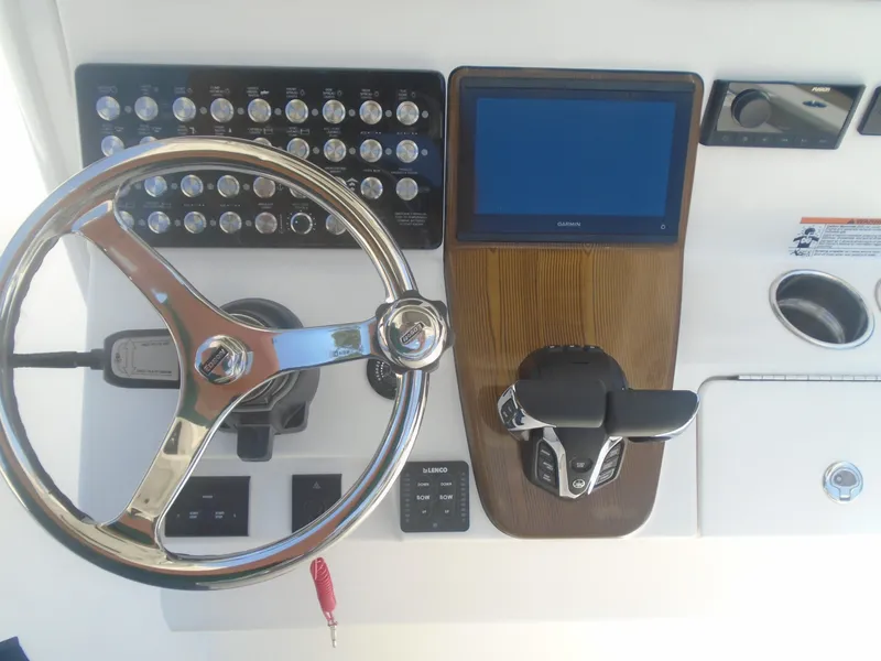 Slide: The Image of 2025 Caymas 291 boat dashboard with steering wheel, control panel, and Garmin display. - 10