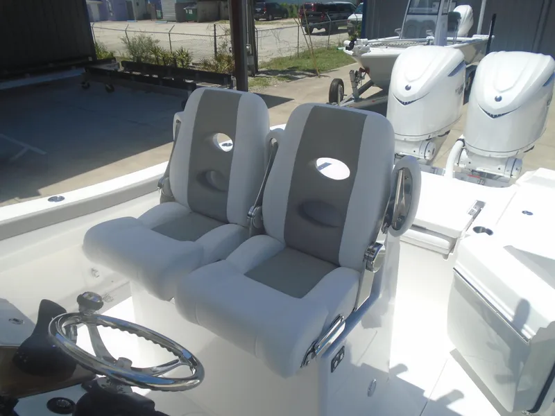 Slide: The Image of 2025 Caymas 291 boat interior with dual seats and steering wheel, featuring twin outboard engines. - 11