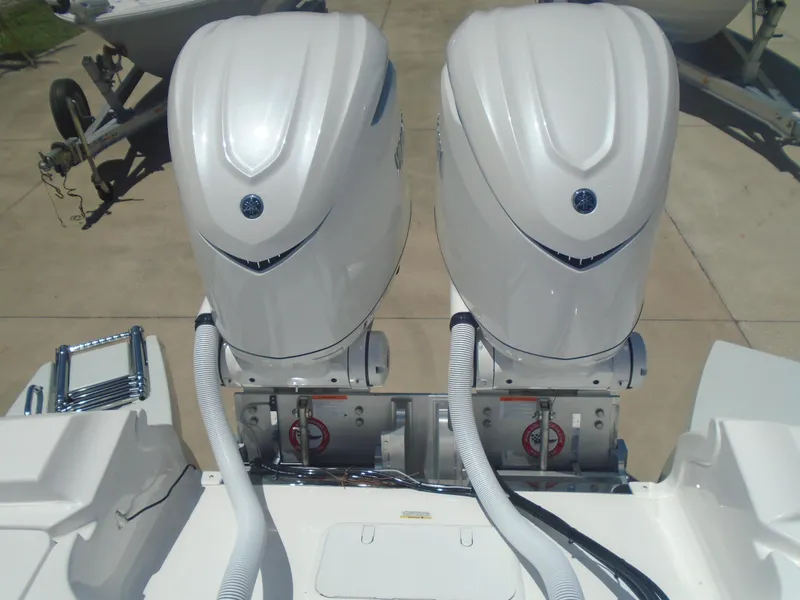 Slide: The Image of Twin outboard engines on a 2025 Caymas 291 boat, parked on a concrete surface. - 14