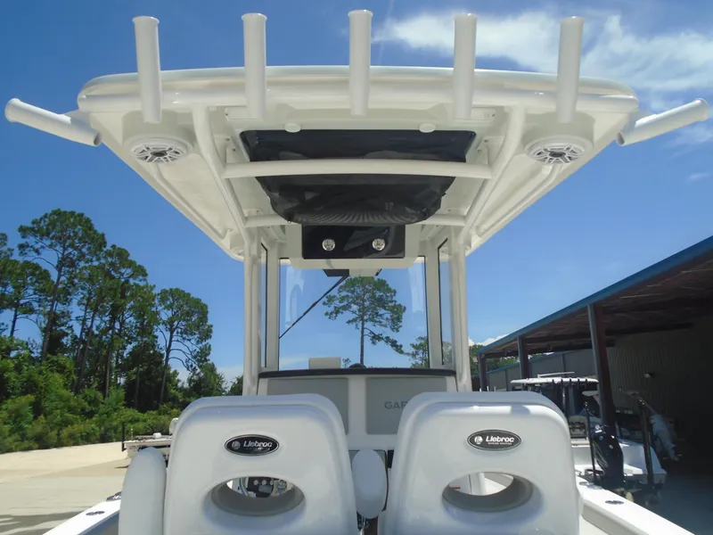 Slide: The Image of 2025 Caymas 291 boat interior with T-top and Lebroc seating under clear blue sky. - 18