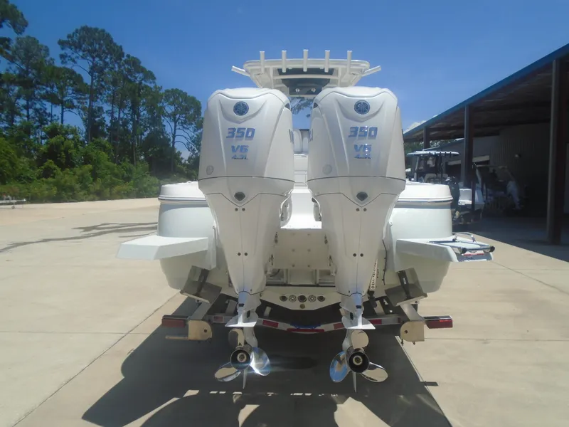 Slide: The Image of 2025 Caymas 291 boat with dual 350 V8 outboard engines, parked outdoors. - 3