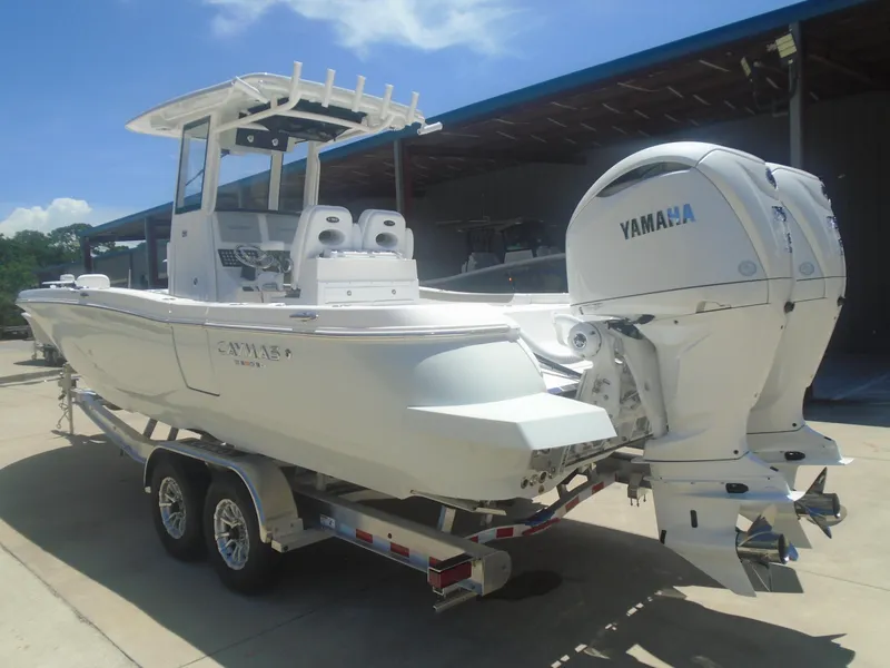 Slide: The Image of 2025 Caymas 291 boat with dual Yamaha engines on a trailer, parked outdoors. - 4