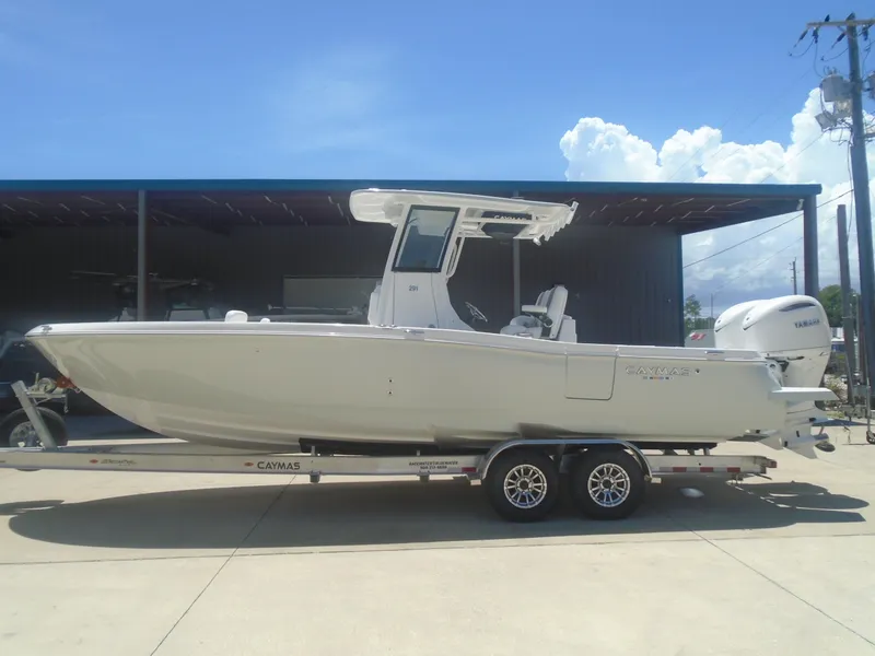 Slide: The Image of 2025 Caymas 291 boat on trailer, parked outdoors under clear blue sky. - 5