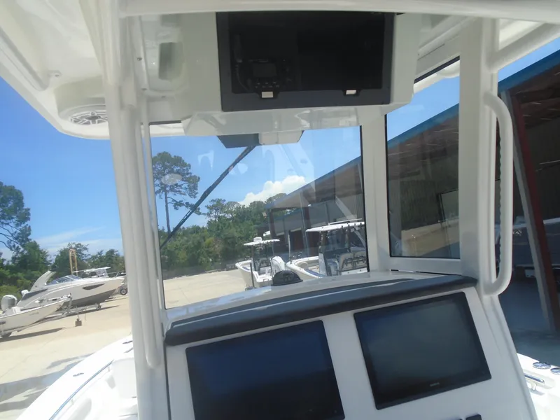 Slide: The Image of 2025 Caymas 291 boat dashboard with dual screens, docked under clear blue sky. - 8