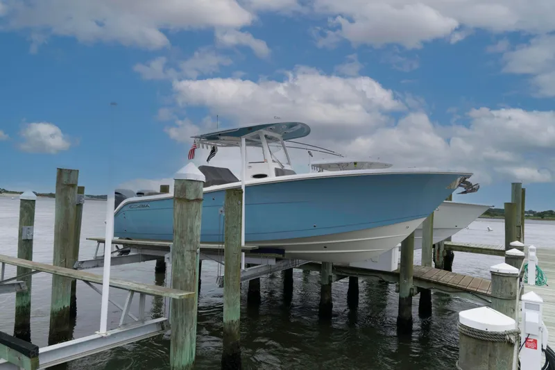 The Image of 2023 Cobia 280 Center Console boat docked under a cloudy sky. - 0