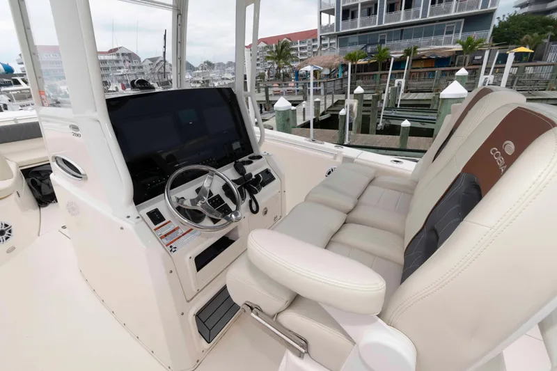 Slide: The Image of 2023 Cobia 280 Center Console boat interior with steering wheel and cushioned seating. - 10
