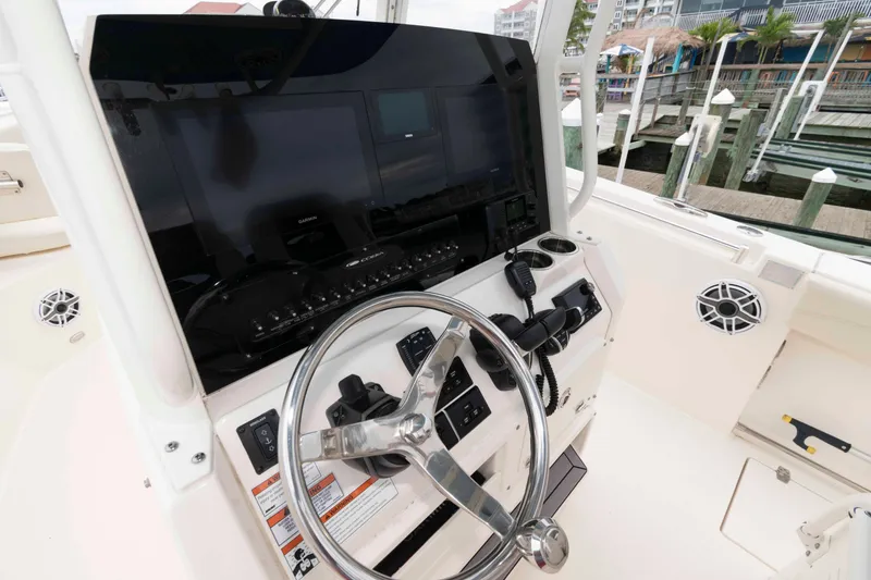 Slide: The Image of 2023 Cobia 280 Center Console helm with steering wheel and navigation display. - 14
