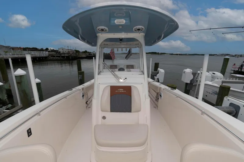Slide: The Image of 2023 Cobia 280 Center Console boat docked by the waterfront under a cloudy sky. - 16