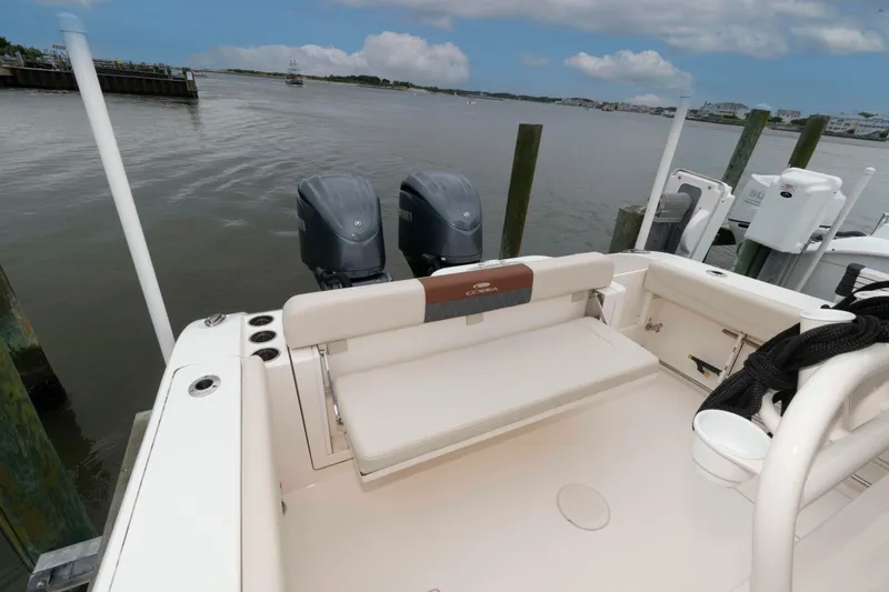Slide: The Image of 2023 Cobia 280 Center Console boat docked, featuring dual outboard motors and spacious seating. - 17