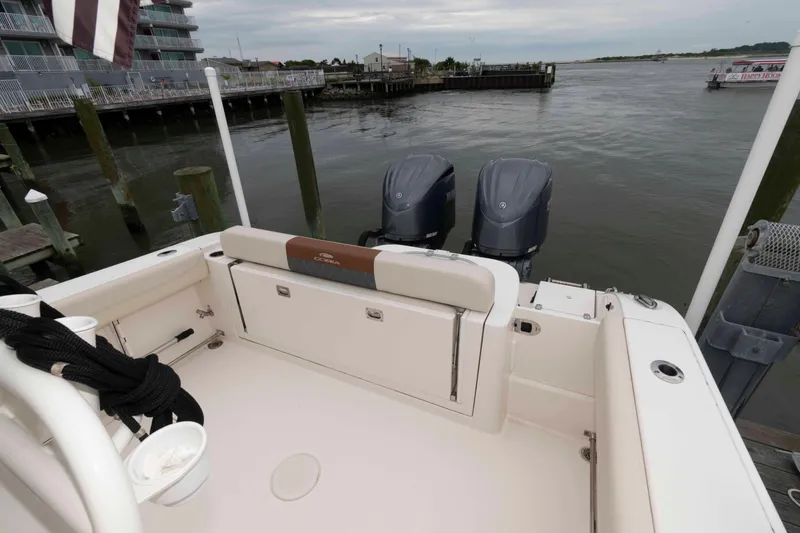 Slide: The Image of 2023 Cobia 280 Center Console boat docked with dual engines, near waterfront buildings. - 18