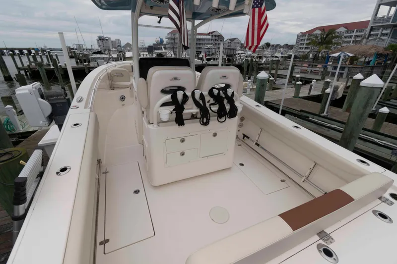 Slide: The Image of 2023 Cobia 280 Center Console boat docked at marina, featuring spacious seating and storage. - 20