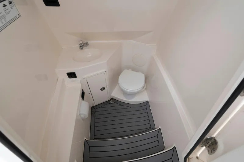 Slide: The Image of 2023 Cobia 280 Center Console boat interior bathroom with sink and toilet. - 23