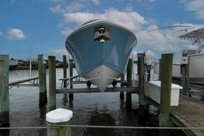 Slide: The Image of 2023 Cobia 280 Center Console boat docked at marina under blue sky. - 5