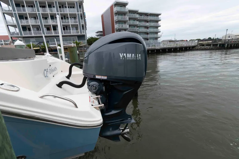 Slide: The Image of 2023 Cobia 280 Center Console with Yamaha outboard motor docked by waterfront buildings. - 6