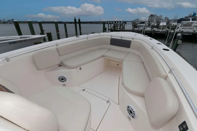 Slide: The Image of 2023 Cobia 280 Center Console boat with spacious seating at a marina. - 7