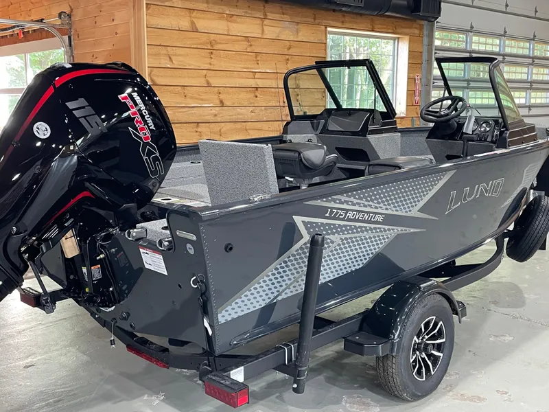 Slide: The Image of 2026 Lund 1775 Adventure Sport boat with Mercury Pro XS engine in a garage setting. - 1