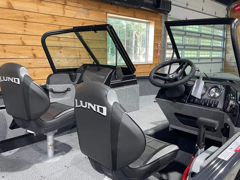 Slide: The Image of 2026 Lund 1775 Adventure Sport boat interior with steering wheel and branded seats. - 7