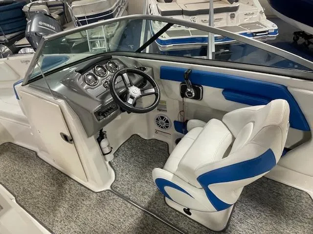 Slide: The Image of 2018 Chaparral 21 H2O Sport boat interior with steering wheel and blue-accented seating. - 9