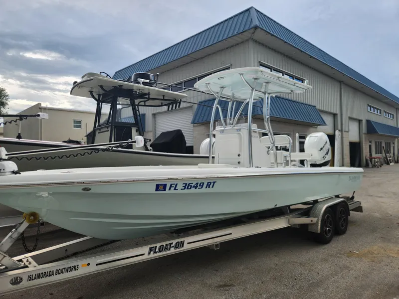 Slide: The Image of 2018 Islamorada Boatworks Morada 24 on trailer, parked outside a warehouse. - 2