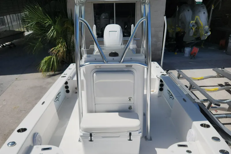 Slide: The Image of 2018 Islamorada Boatworks Morada 24 interior with seating and console, docked outdoors. - 7