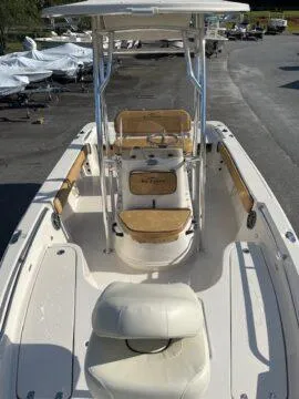 Slide: The Image of 2024 Sea Chaser LX boat with center console and cushioned seating, docked outdoors. - 4