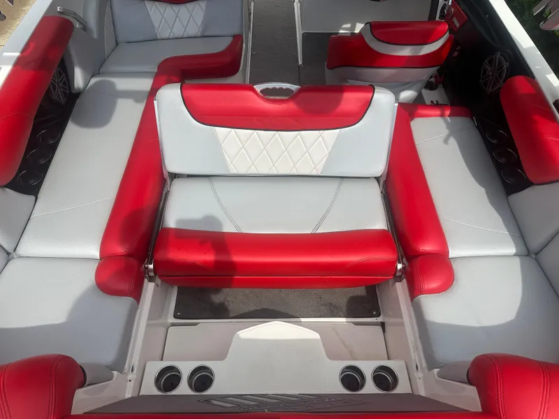Slide: The Image of 2015 MasterCraft X10 boat interior with red and white seating, cup holders, and stylish design. - 11