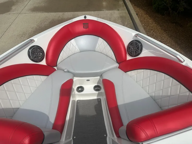 Slide: The Image of 2015 MasterCraft X10 boat interior with red and gray seating, featuring speakers and cup holders. - 13