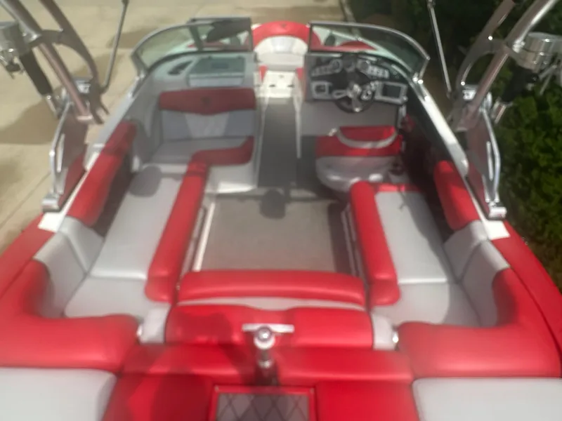 Slide: The Image of 2015 MasterCraft X10 boat interior with red and gray seating, sleek design, and modern dashboard. - 4