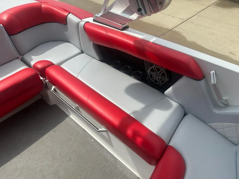 Slide: The Image of 2015 MasterCraft X10 boat interior with red and gray seating, cup holders, and speaker. - 7