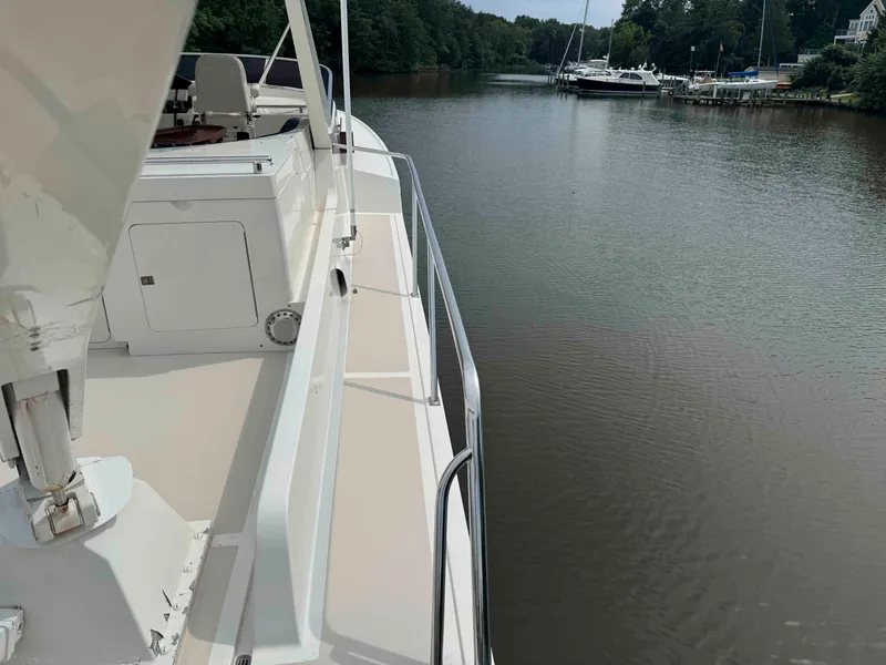 Slide: The Image of Side view of a 2002 Marlow 70E yacht on a calm river. - 14