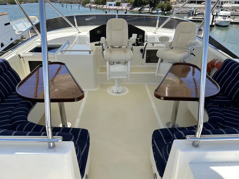 Slide: The Image of Luxurious 2002 Marlow 70E yacht deck with seating and helm, overlooking marina. - 15