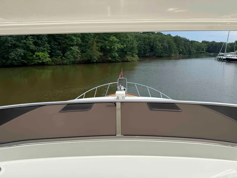 Slide: The Image of Front view from a 2002 Marlow 70E yacht navigating a serene river. - 16