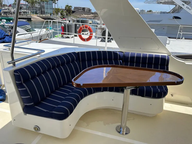 Slide: The Image of Luxurious seating area on a 2002 Marlow 70E yacht with striped cushions and wooden table. - 18