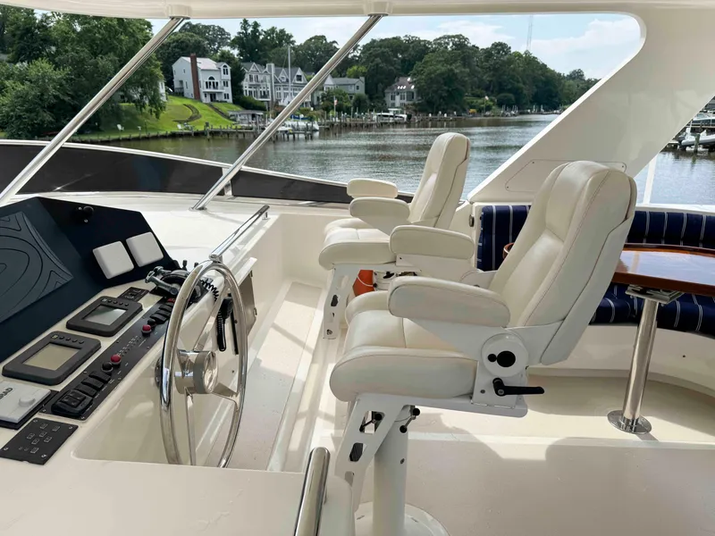Slide: The Image of Helm of 2002 Marlow 70E yacht with white captain chairs and control panel. - 21