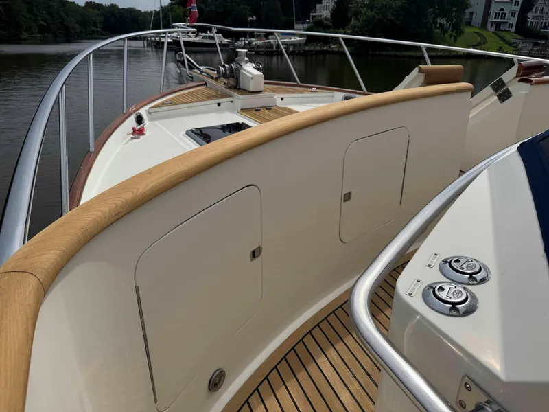Slide: The Image of Deck view of a 2002 Marlow 70E yacht with wooden railings and metal fixtures. - 32