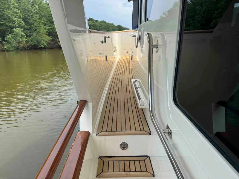 Slide: The Image of Side deck of a 2002 Marlow 70E yacht with wooden flooring and railing. - 33