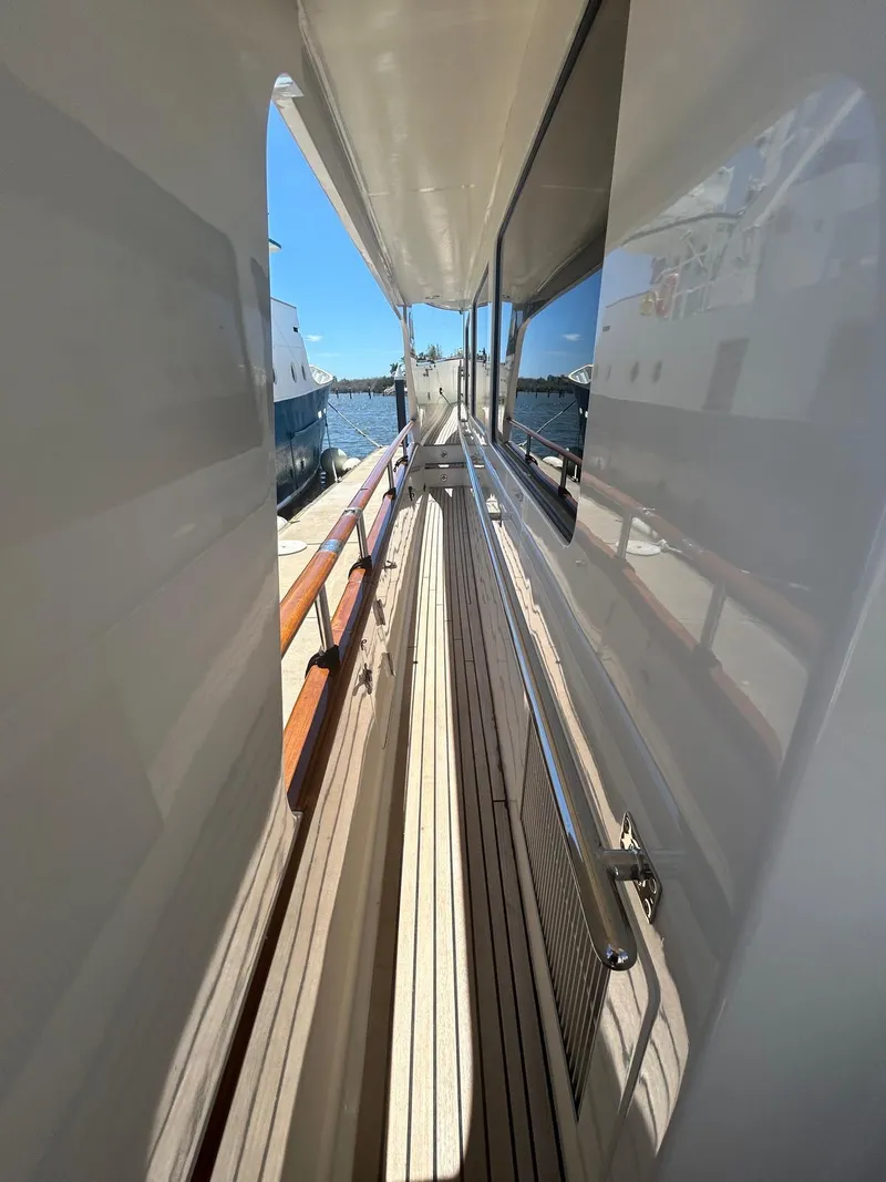 Slide: The Image of Narrow deck passage on 2002 Marlow 70E yacht, featuring wooden railings and ocean view. - 35