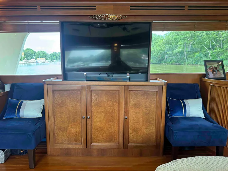Slide: The Image of Luxurious Marlow 70E yacht interior with TV, wooden cabinet, and plush seating, 2002 model. - 46