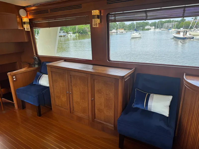 Slide: The Image of Luxurious Marlow 70E yacht interior with blue chairs, wooden cabinetry, and scenic water view. - 47