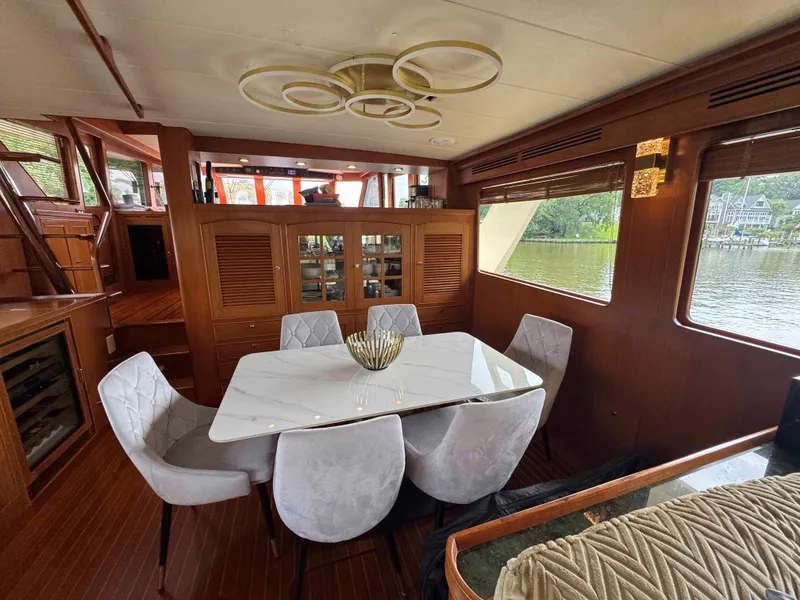 Slide: The Image of Luxurious dining area on a 2002 Marlow 70E yacht with elegant decor and waterfront views. - 49
