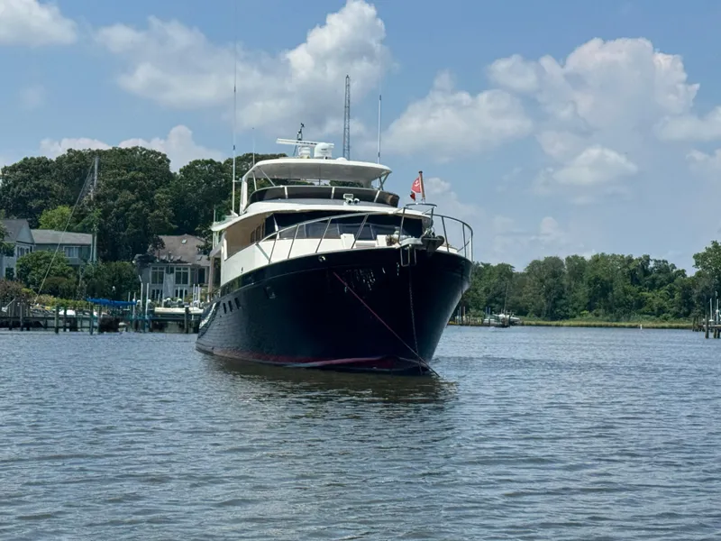 Slide: The Image of Luxury Marlow 70E yacht from 2002 anchored on a serene waterway. - 5