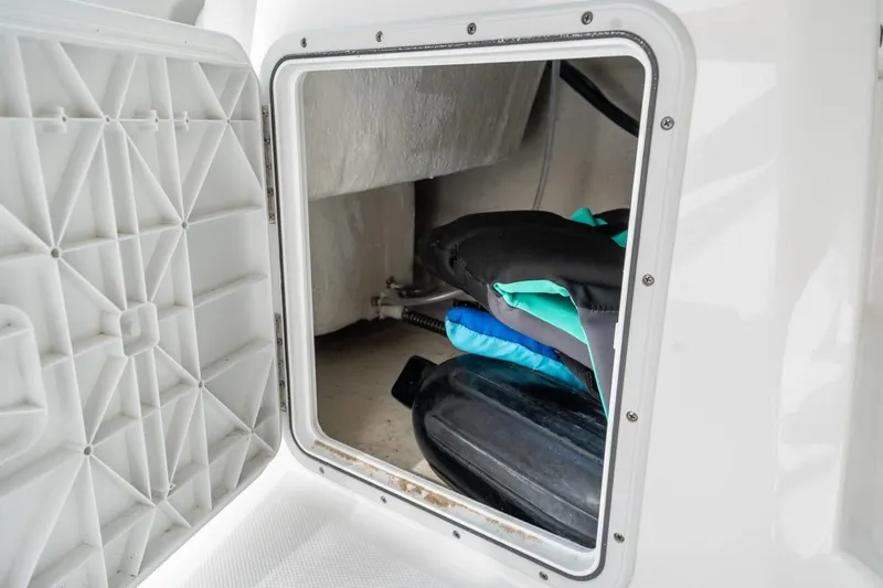 Slide: The Image of Storage compartment on 2025 Hurricane SunDeck 2050 OB boat, showing life jackets inside. - 10