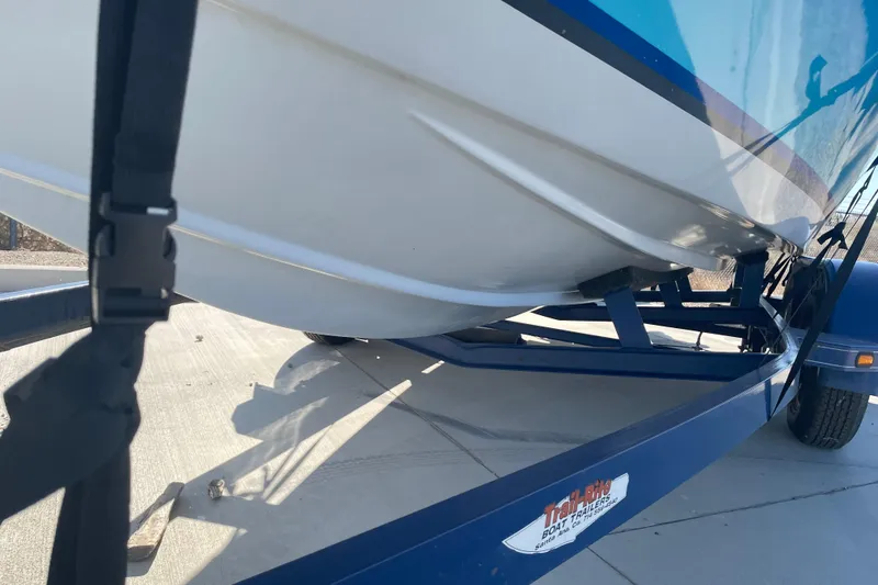 Slide: The Image of 1989 Galaxie 1900 Starion boat on trailer, secured with straps, parked on concrete. - 16