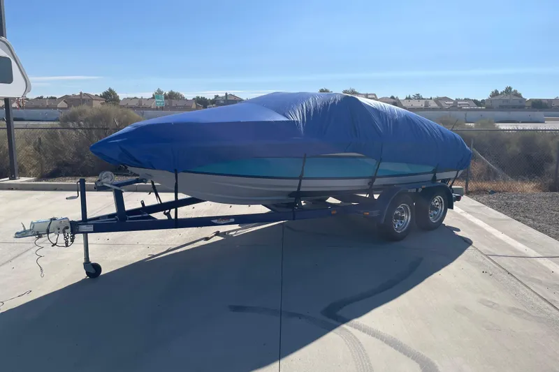 Slide: The Image of Covered 1989 Galaxie 1900 Starion boat on trailer in sunny outdoor setting. - 6